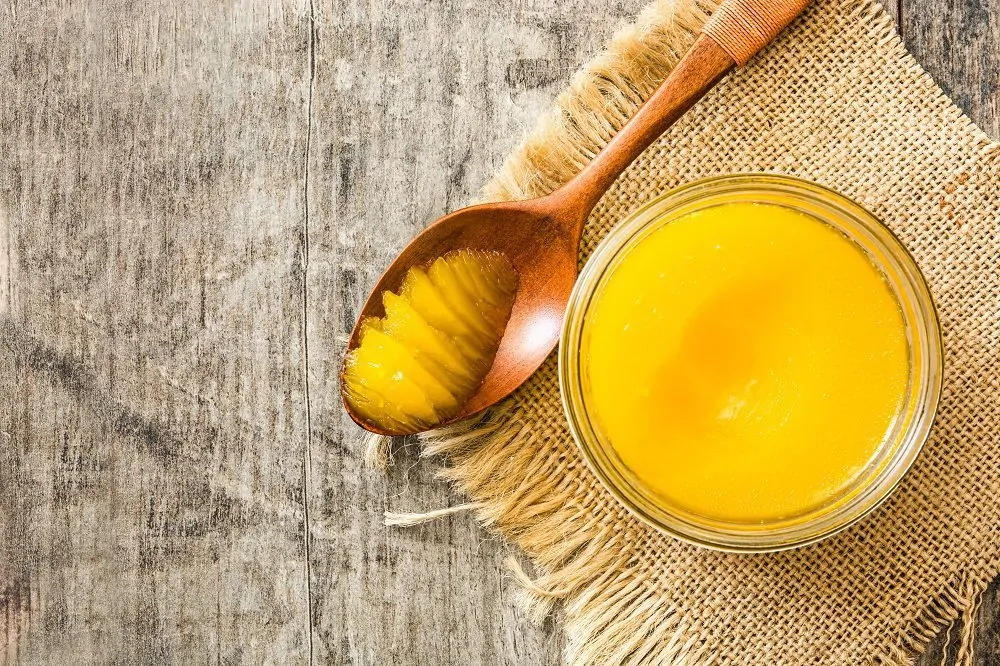 Ghee,Or,Clarified,Butter,In,Jar,And,Wooden,Spoon,On